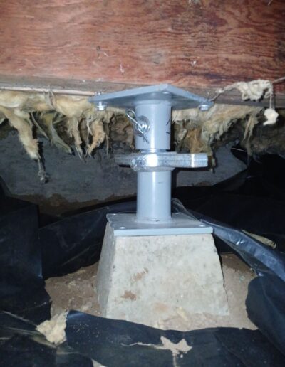 adjustable steel support post installed in a crawl space to stabilize a home's foundation