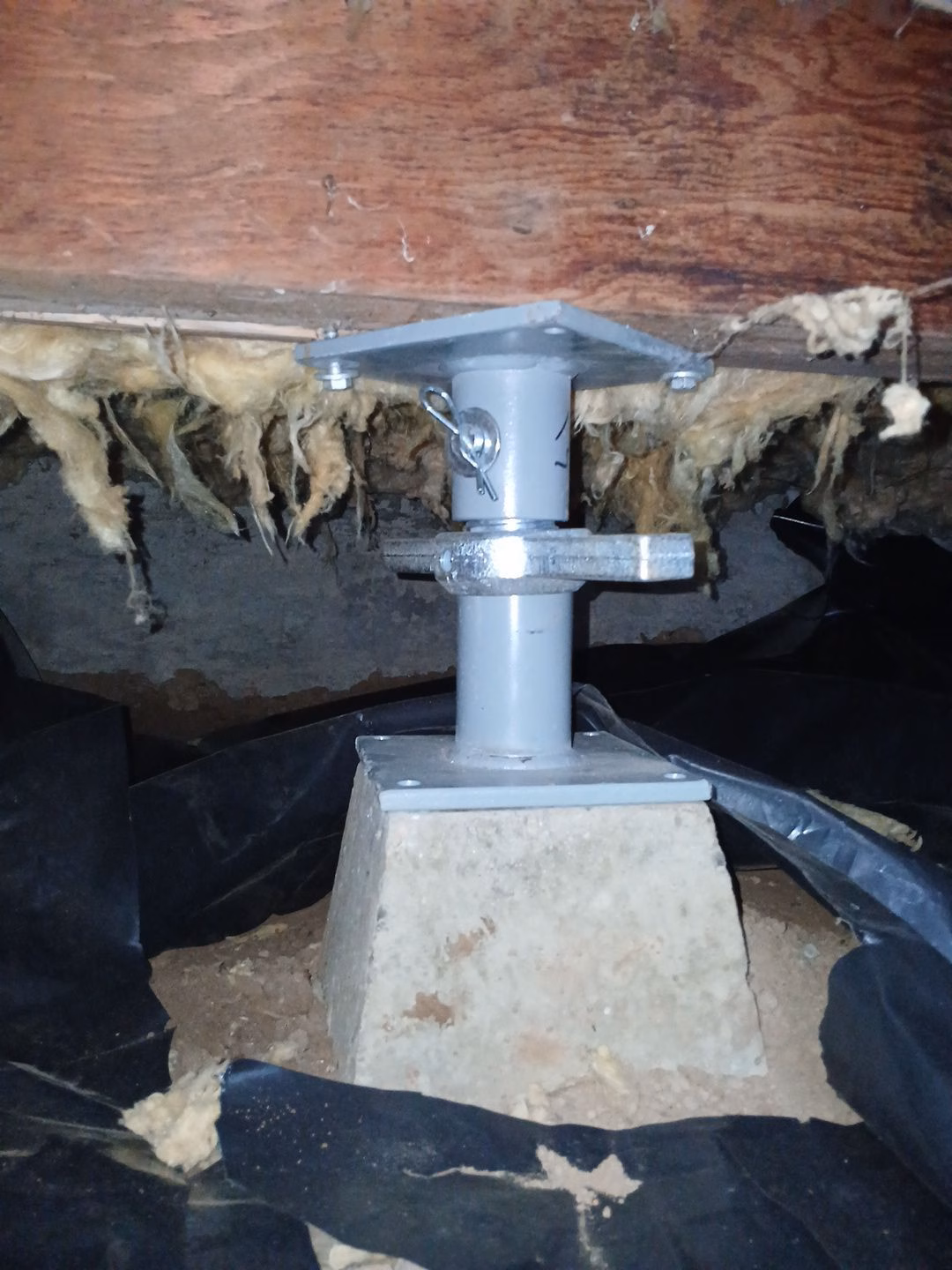 adjustable steel support post installed in a crawl space to stabilize a home's foundation